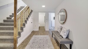 Eine Treppe mit hölzernen Geländern, einem gemusterten Teppich und einer Bank mit gemusterten Kissen.