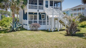 A two-story house with a balcony, surrounded by tropical plants. - Walk to Water: Coastal-Chic Home Near Myrtle Beach (Atlantic Beach)