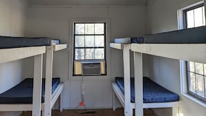 A room with bunk beds, a ceiling fan, a window, and an air conditioning unit. -  Come enjoy the Ocoee River and all its beautiful nature with us! (Benton)