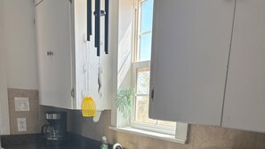 A kitchen with a double sink, a coffee maker, a microwave, and cabinets. - Comfy 2 bedroom home, near Palo Duro Canyon! (Canyon)