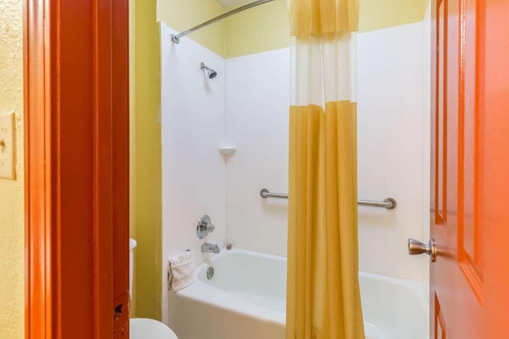 A bathroom with a bathtub, shower, and toilet.