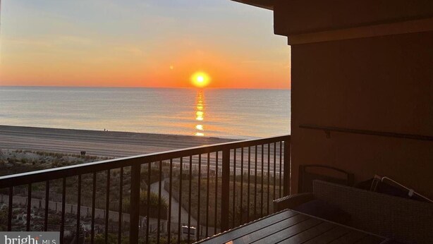A balcony with a view of the sunset over the ocean. - OCEANFRONT with Balcony, Updated Condo; Gorgeous views; sleeps 6 (Ocean City)