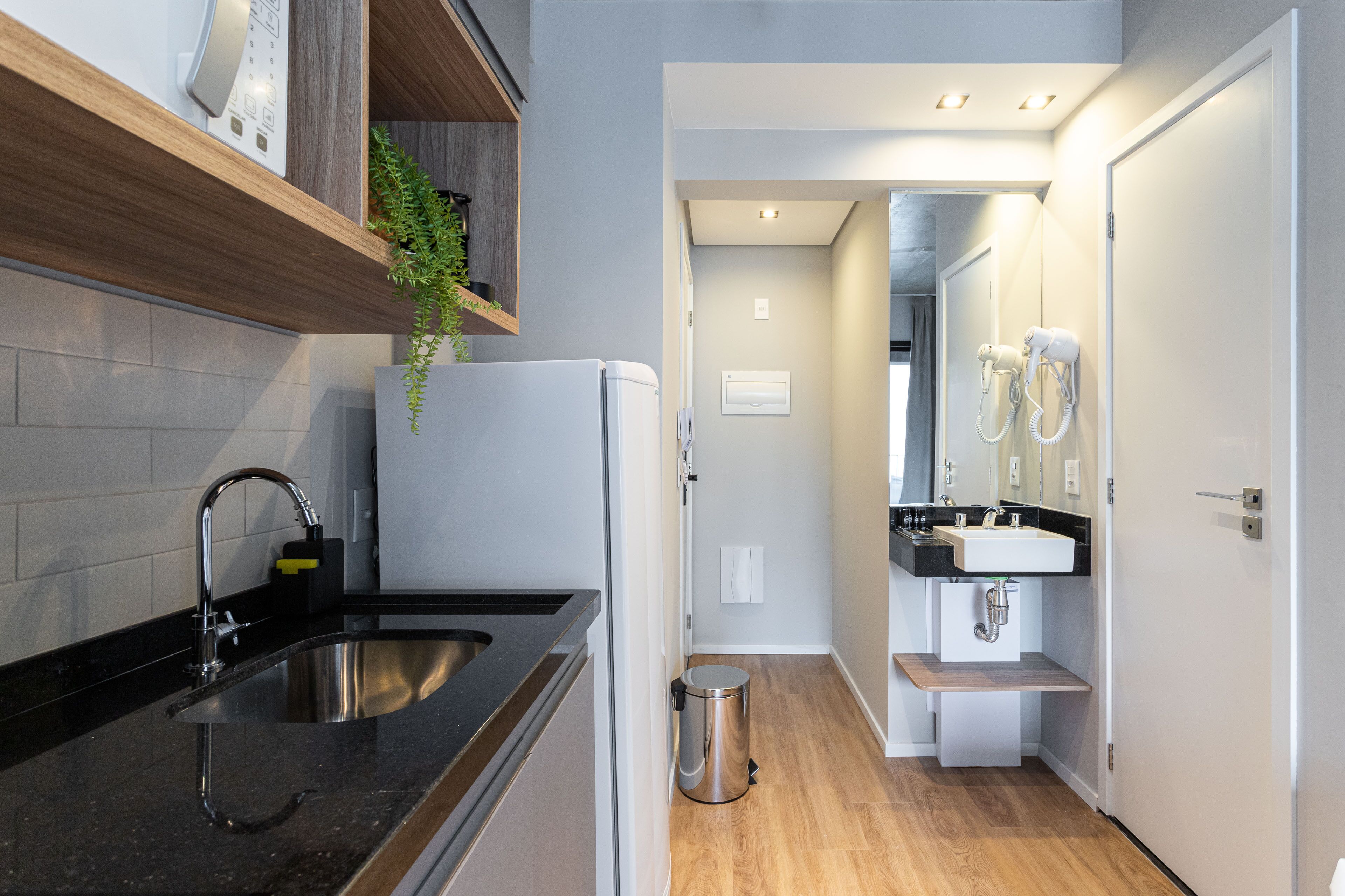 Een moderne keuken met een roestvrijstalen spoelbak, houten planken en een ingebouwde oven.