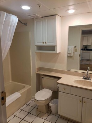 Un baño con bañera, inodoro, lavabo y espejo.