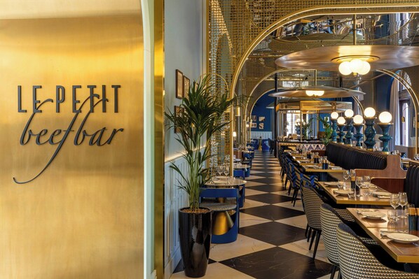 A restaurant interior with a checkered floor, tables set for dining, and a sign reading "LE PETIT beefbar". - W Budapest (Budapest)