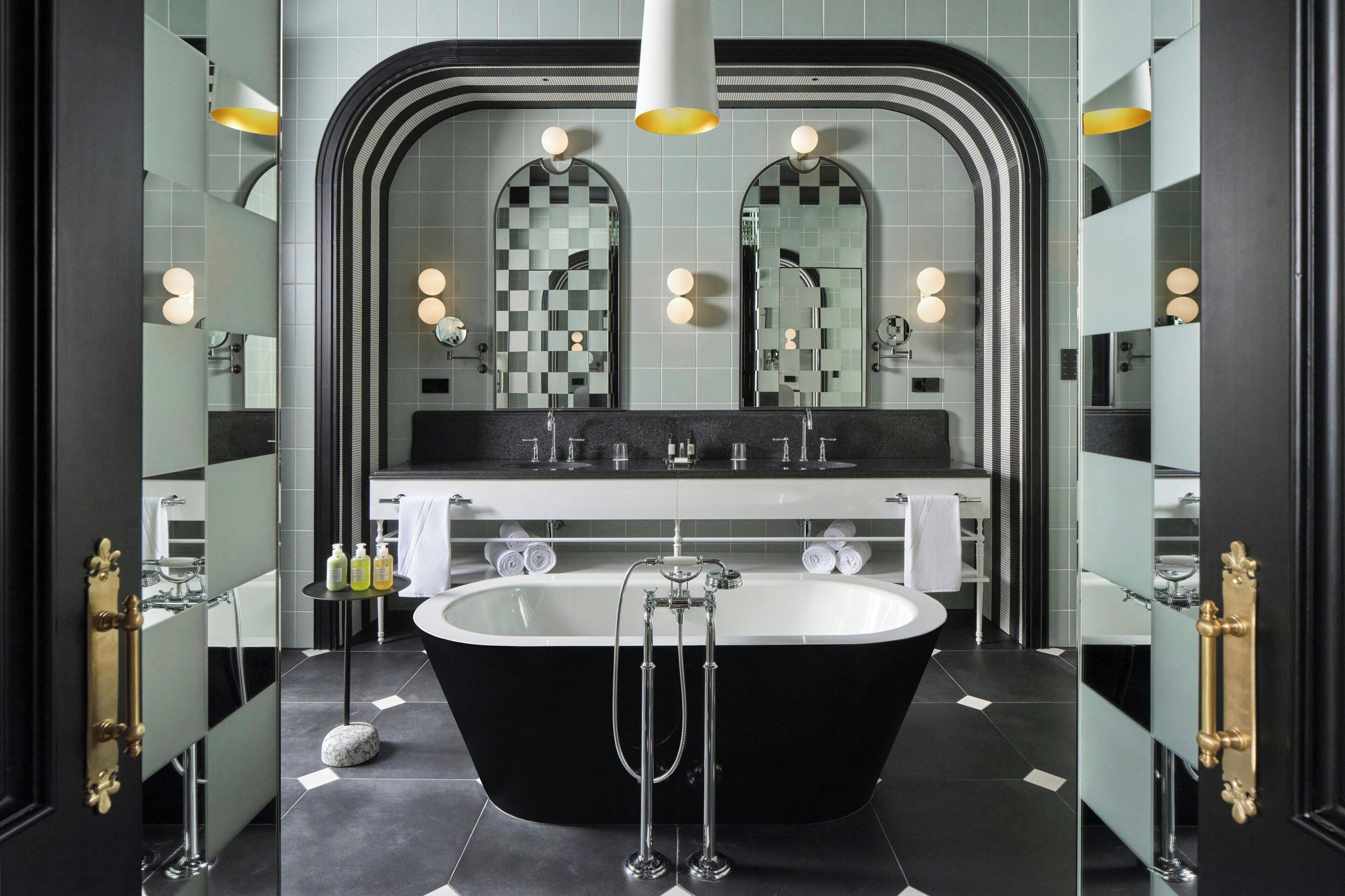 A modern bathroom with a freestanding bathtub, a large mirror, and a vanity with a sink.
