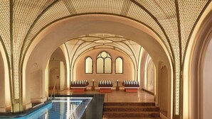 A spacious indoor swimming pool with arched ceilings and seating areas. - W Budapest (Budapest)