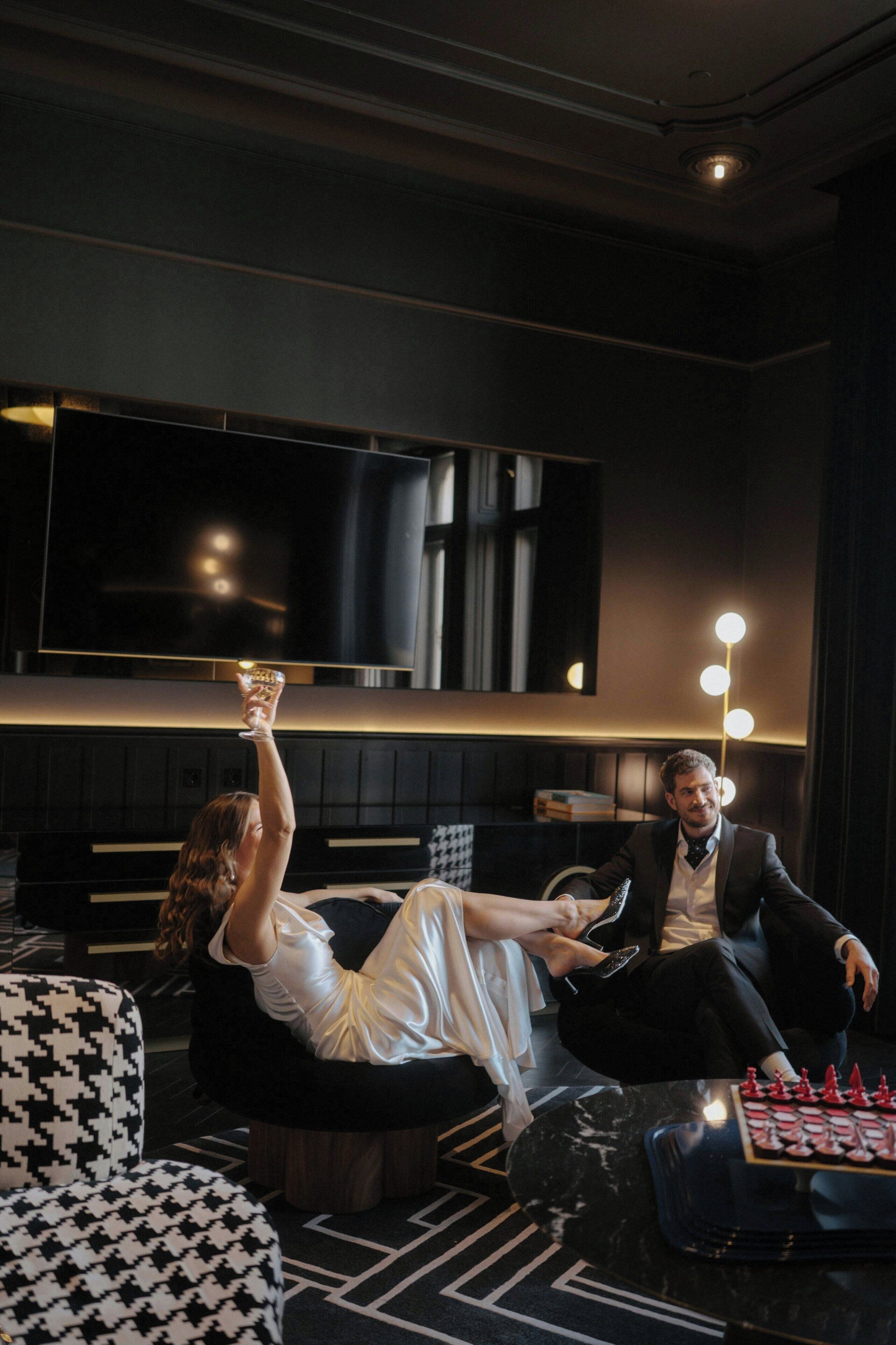 A modern living room with a large flat-screen TV, a sofa, and a coffee table with a chess set.