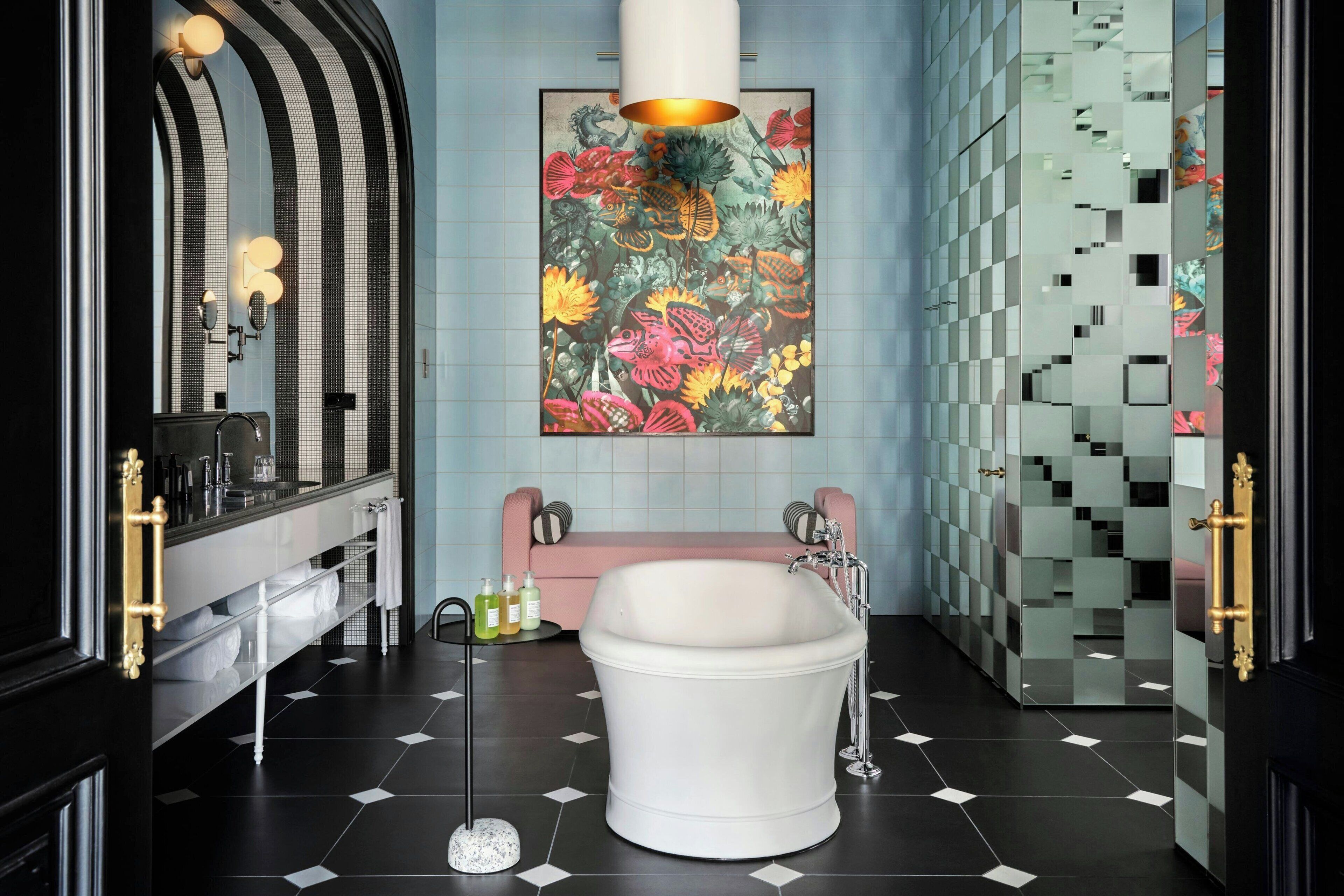 Un baño moderno con una bañera independiente, un espejo grande y un cuadro abstracto y colorido en la pared.