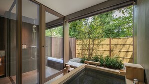 Ein modernes Badezimmer mit einer gläsernen Dusche, einer kleinen Sitzecke und einem Pool.