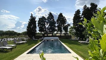 Una piscina al aire libre de temporada, sombrillas