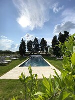 Una piscina al aire libre de temporada, sombrillas