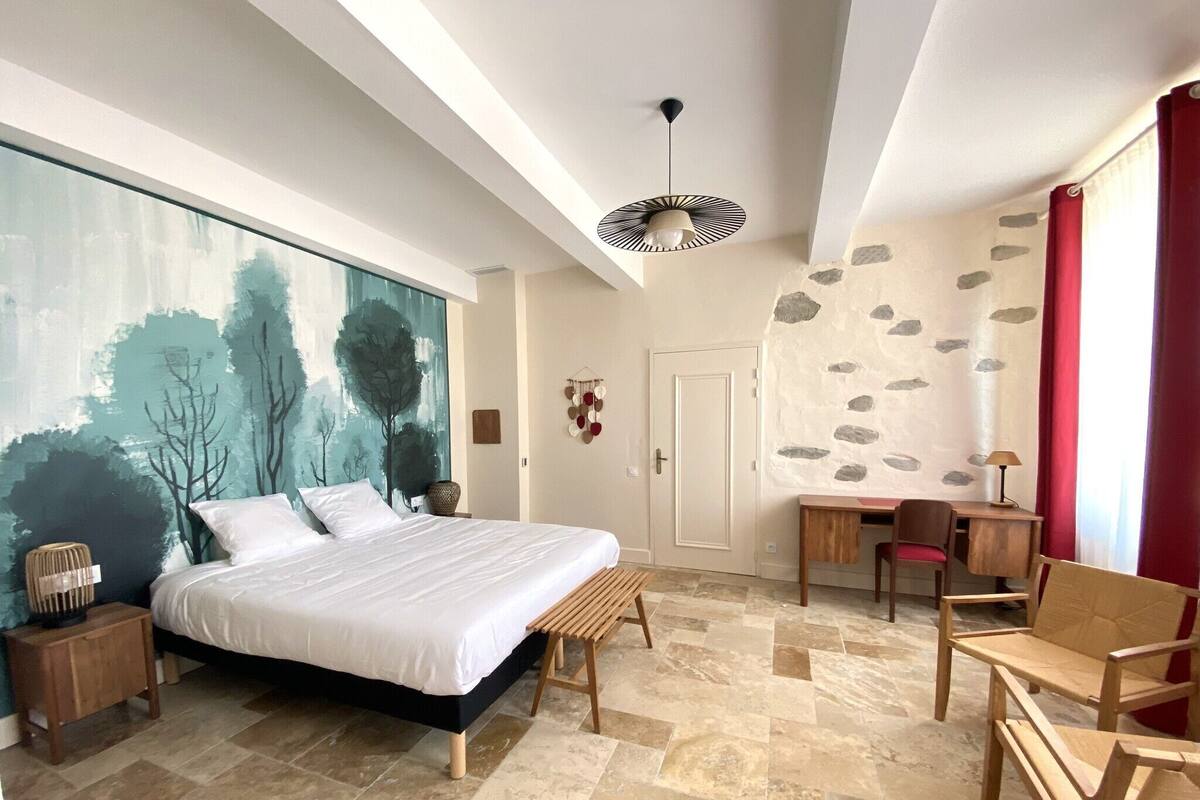 Un dormitorio con cama, escritorio y silla.
