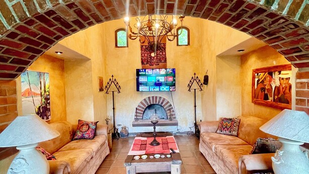 A cozy living room with a fireplace, two sofas, a coffee table, and a television.
