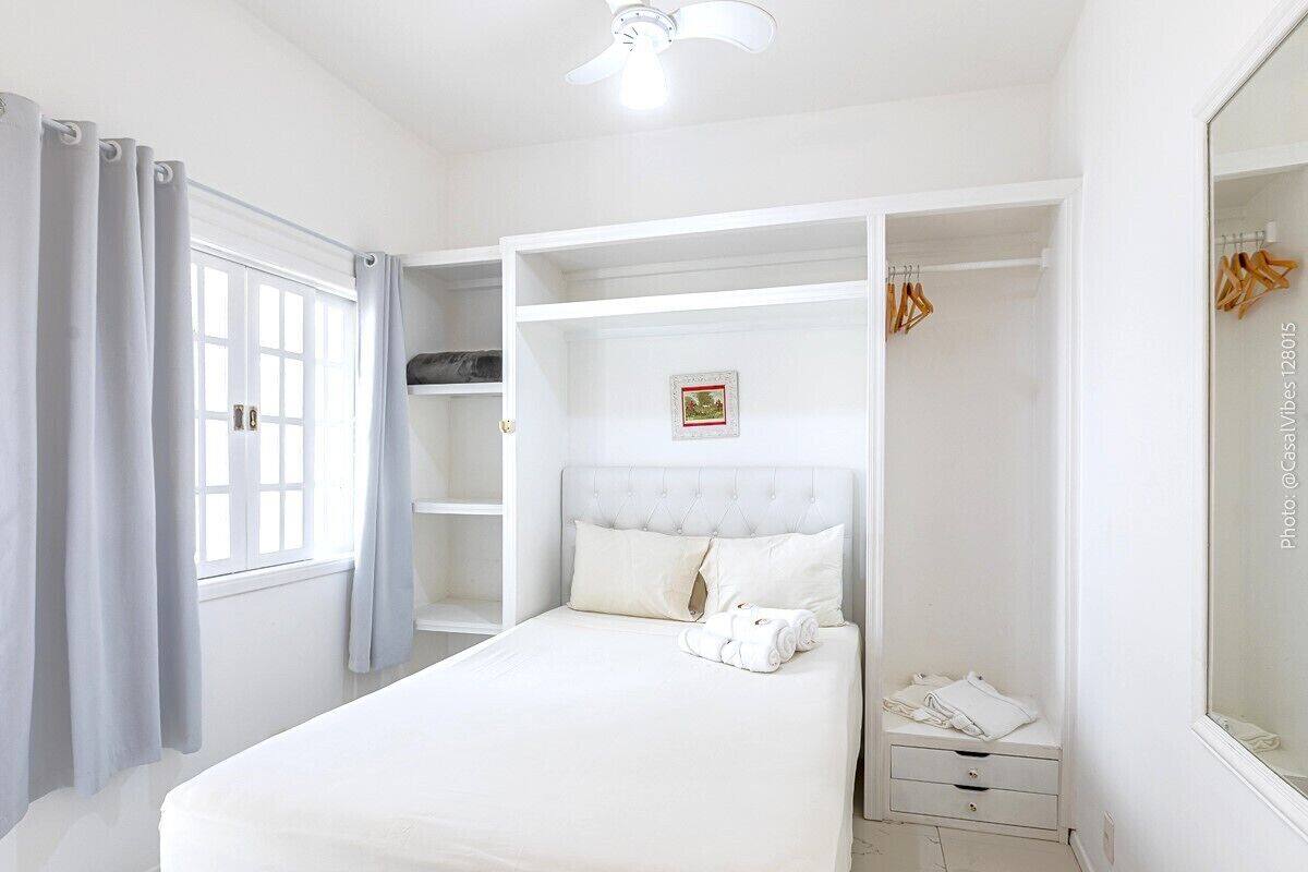 Une chambre à coucher avec un lit, une armoire et un miroir.