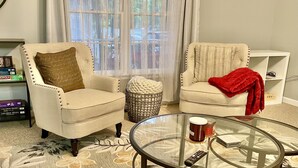 A living room with two armchairs, a glass coffee table, and a patterned carpet. - Cozy house in Ocean pines, only 10 mins away from Ocean City. (Ocean Pines)