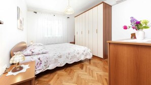 A bedroom with a bed, a desk, a wardrobe, and a hanging light fixture. - MAXI One-Bedroom Apartment 2 (Rovinj)