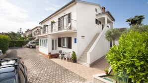 A two-story house with a balcony, a staircase, and a paved driveway. - MAXI One-Bedroom Apartment 2 (Rovinj)