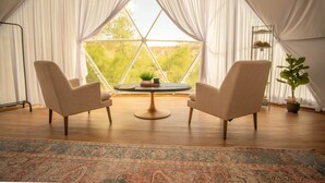 A tented room with two chairs, a table, and a view of greenery outside. - Capitol Reef Dome | Oak (Wayne County)