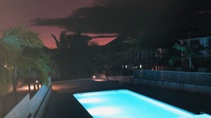 En nattbild av en swimmingpool med en klar himmel ovanför.