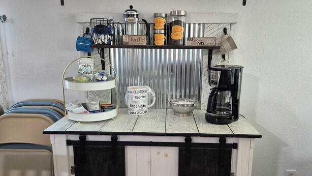 A kitchenette with a coffee maker, a mug, a bowl, and a shelf with coffee containers. -  Songbird Haven, 3 min from town, Pumpkinvine, MEC,concerts. 3 bedroom, 2 bath.  (Shipshewana)