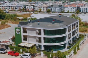 A multi-story building with a curved facade, air conditioning units, and a rooftop with spherical decorations. - Let'stay Marine Homes (Antalya)