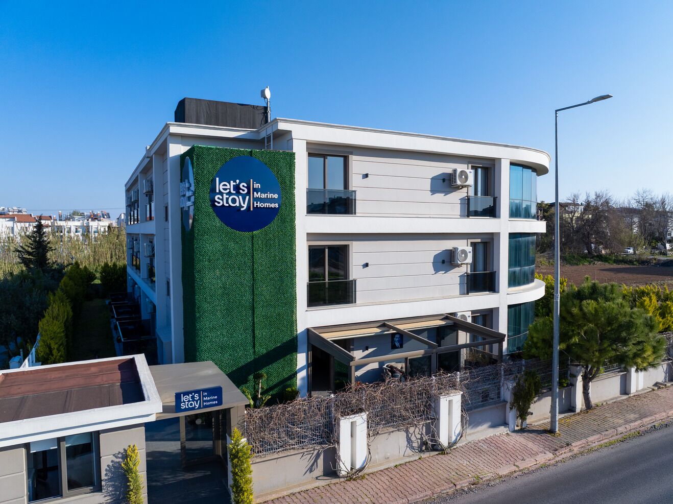 A modern building with a sign reading 'let's stay in Marine Homes.'