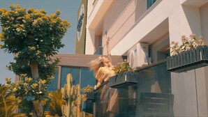 A building with a modern design, featuring a balcony with a railing and potted plants. - Let'stay Marine Homes (Antalya)