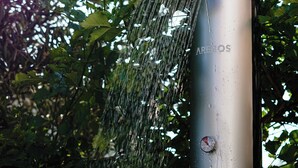 A water feature with a metallic structure and a visible brand name, surrounded by lush greenery.