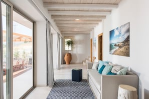 Um interior moderno com sofá, tapete estampado, piso de madeira e uma janela grande.