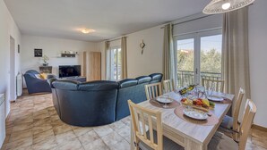 Una sala de estar moderna con un sofá, una mesa de comedor y una televisión.