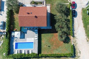 An aerial view of a property with a swimming pool, a covered patio, and a red-roofed building. - Pool House Lilly (Visnjan)