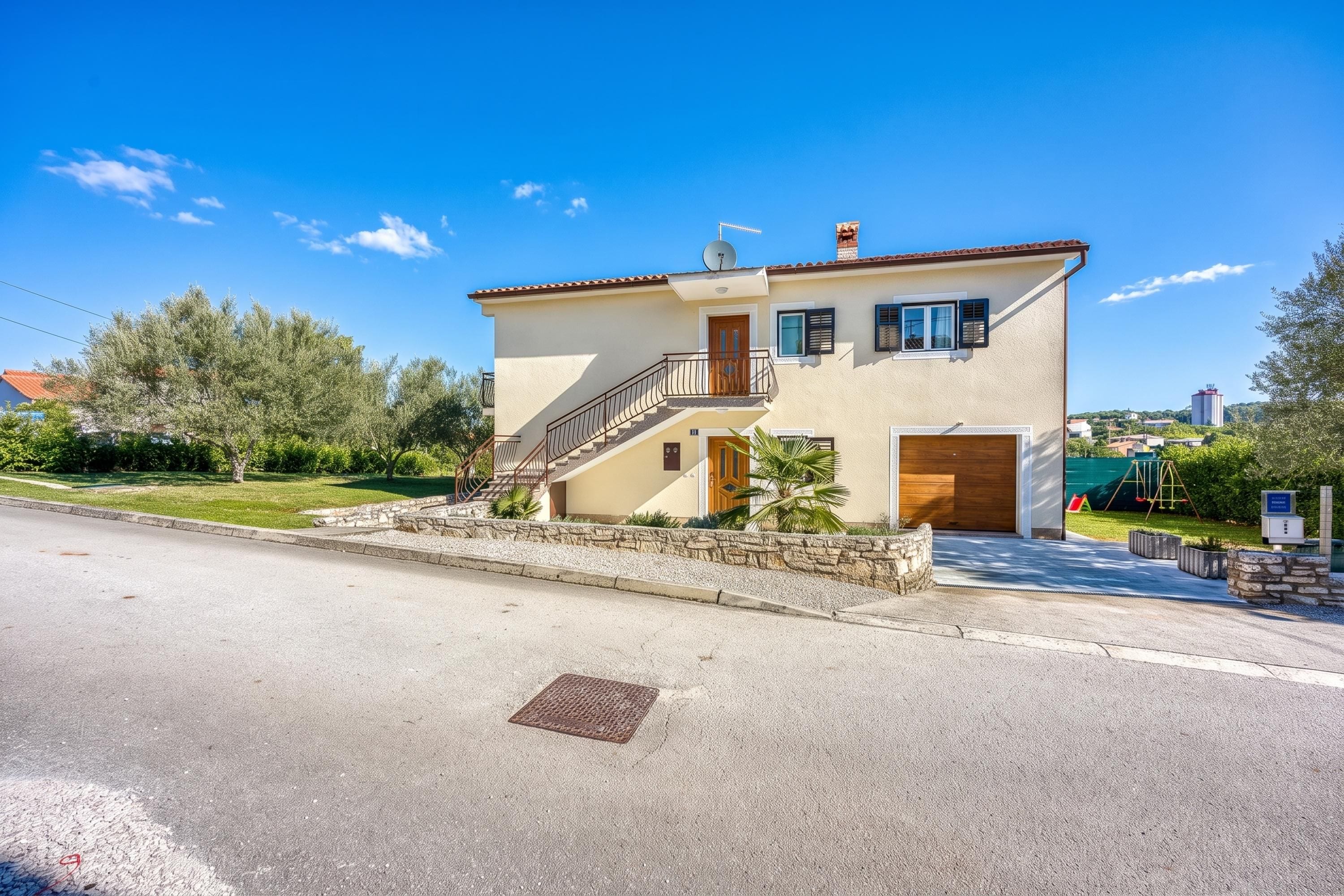 Una casa a due piani con un ingresso principale, una scala e un garage.