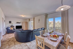 A modern living room with a sofa, a dining table set for two, and a television. - Pool House Lilly (Visnjan)