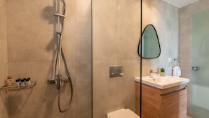 Ein modernes Badezimmer mit einer gläsernen Duschkabine, einem Holzwaschtisch mit Waschbecken und einer Toilette.