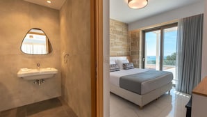 Ein modernes Badezimmer mit Waschbecken und Spiegel, sowie ein Schlafzimmer mit Bett und großen Fenstern.