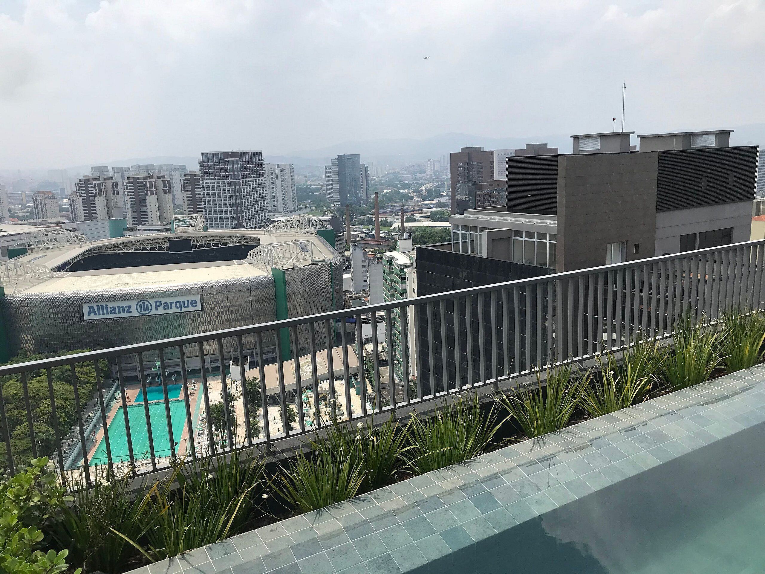 Une piscine sur le toit offrant une vue sur l’Allianz Parke et les bâtiments environnants.