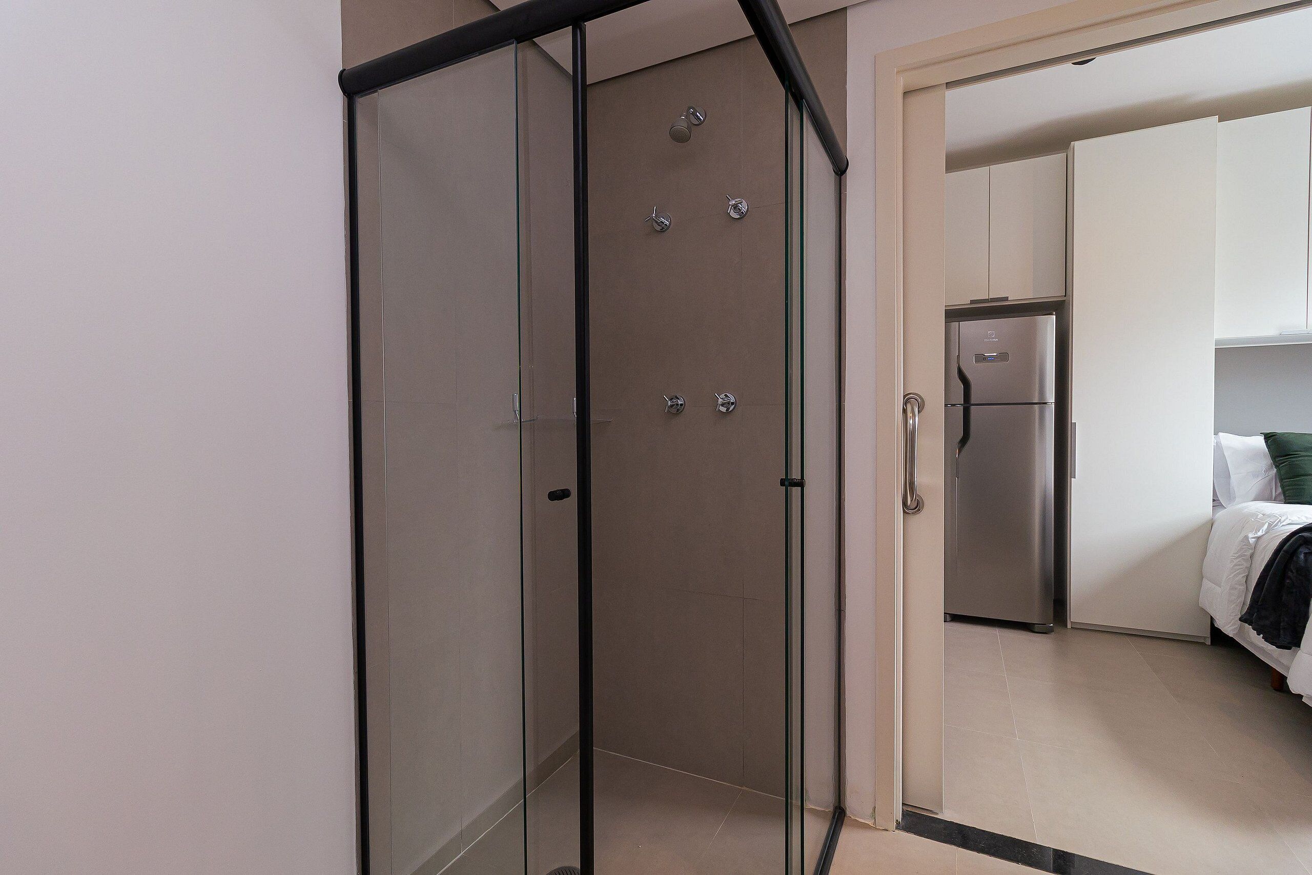 A modern bathroom with a glass shower enclosure, a toilet, and a sink.