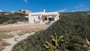 A modern house with a patio, a bicycle, and a clear view of the surrounding landscape. - Falasarna Seafront House I 50 m to the Beach (Kissamos)