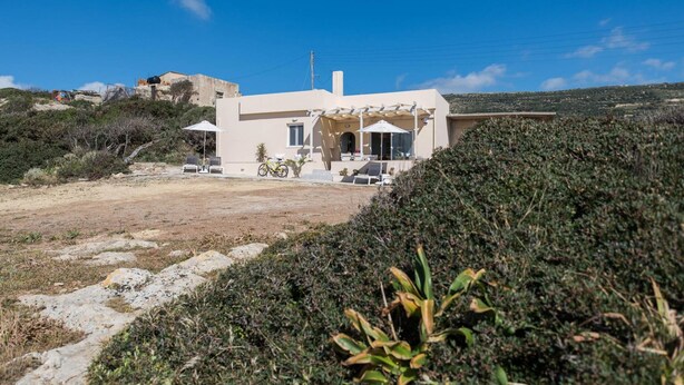 A modern house with a patio, a bicycle, and a clear view of the surrounding landscape. - Falasarna Seafront House I 50 m to the Beach (Kissamos)