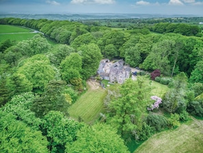 Surrounded by lush greenery, this traditional country house offers a serene and secluded environment with a spacious main building and well-maintained lawn.