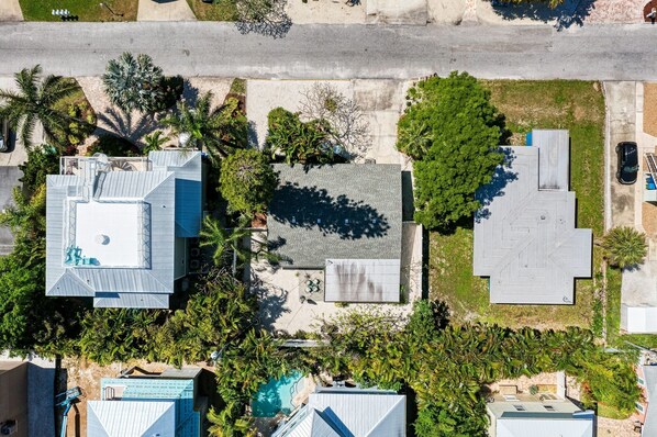 Vista aérea de una zona residencial con varias casas, una piscina y follaje circundante.