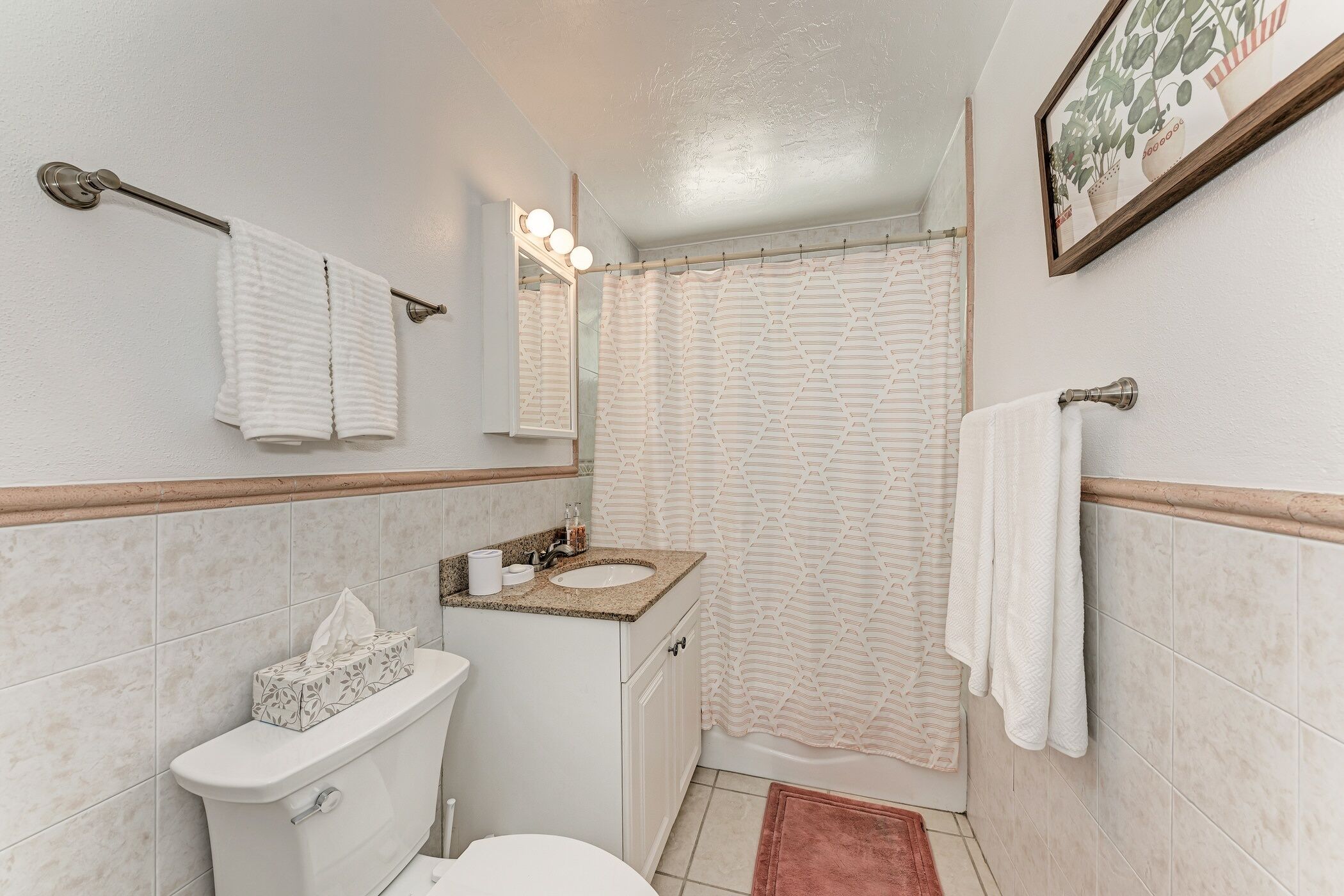 A bathroom with a toilet, sink, and shower curtain.