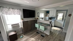 A compact kitchen with a central island, a microwave, and a sink. - Perfectly Small House (Xenia)
