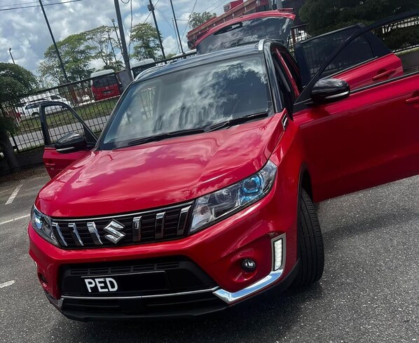 Une voiture rouge est garée dans la rue.