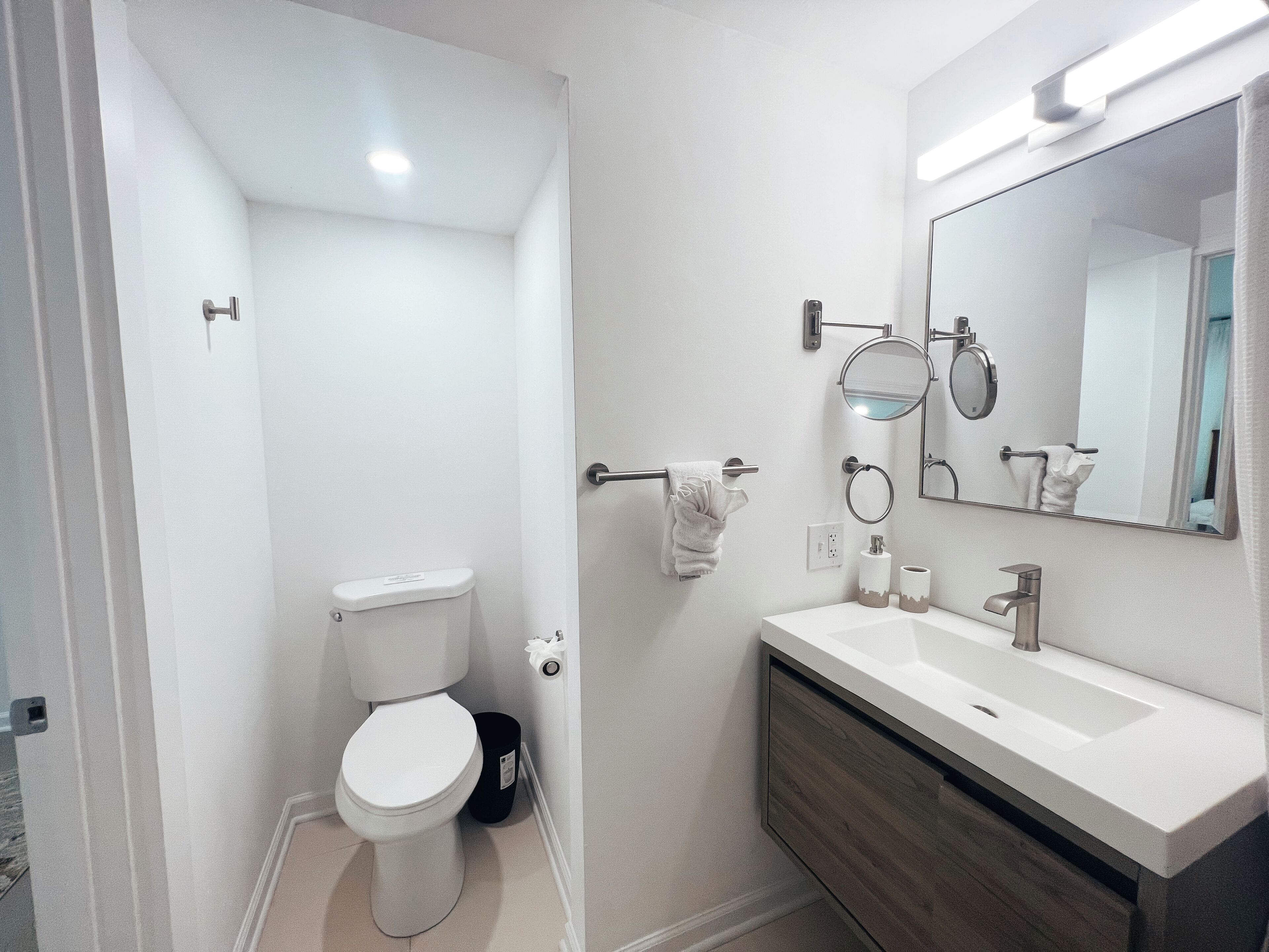 A modern bathroom with a toilet, sink, and mirror.