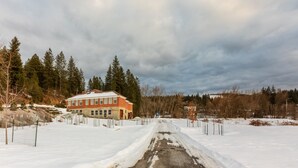 A snow-covered landscape with a building and a road. - Historic High School - Stays and events close to skiing, golf, fishing, hunting! (Kingston)