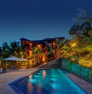 A multi-story resort with a swimming pool, surrounded by lush tropical vegetation. - Chocolate Hotel (Itacaré)