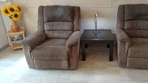 Twee bruine fauteuils met een kleine tafel ertussen.