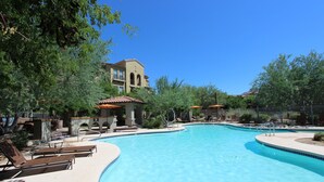 Ein Pool mit Liegestühlen und einem Gebäude im Hintergrund.